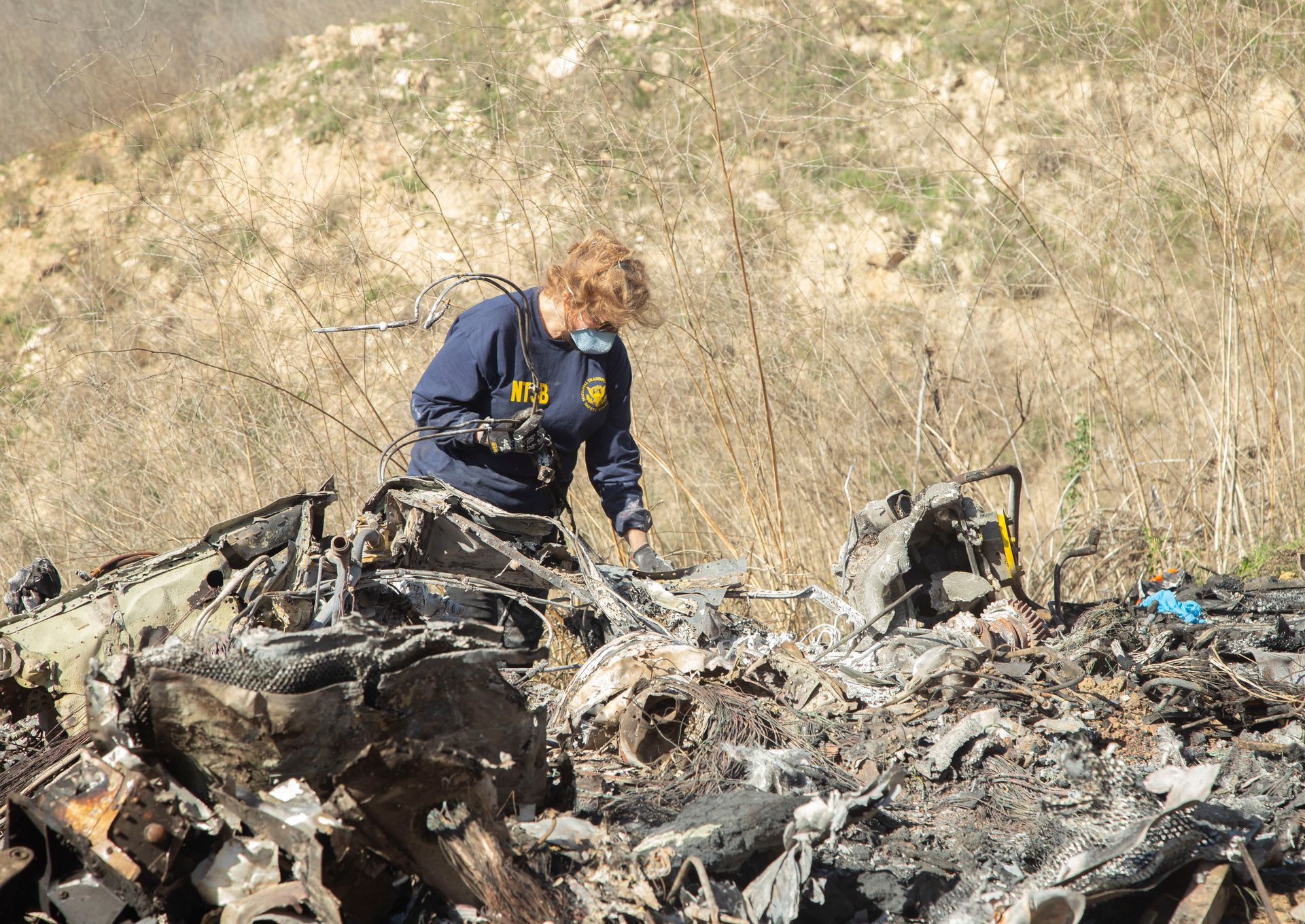 Carol Hogan examines wreckage as part of the NTSB’s investigation of the crash of a Sikorsky S76B helicopter near Calabasas, California, Jan. 26.